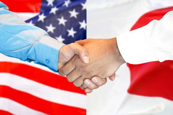 handshake on american and Japanese flag background.