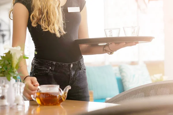 Chica trabajando como camarera sosteniendo una bandeja con té —  Fotos de Stock