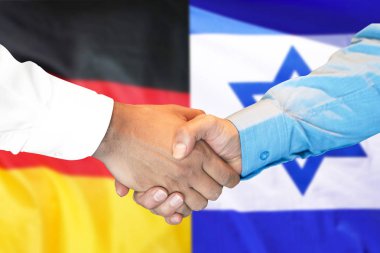 Almanya ve İsrail bayrağı arka planda el sıkışma.