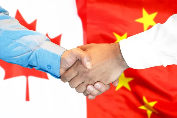 Apretón de manos en el fondo de la bandera de Canadá y China . — Foto de Stock