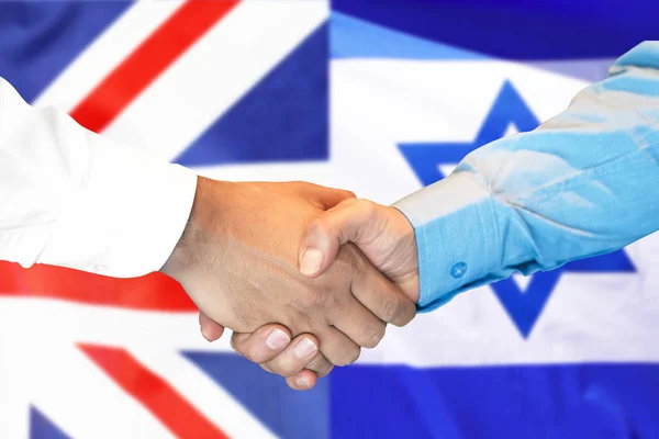 handshake on United Kingdom and Israel flag background.