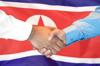 Kuzey Kore bayrağı arka planda el sıkışma.