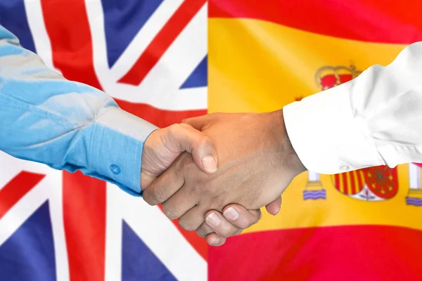 Aperto de mão em Espanha e fundo da bandeira do Reino Unido . — Fotografia de Stock
