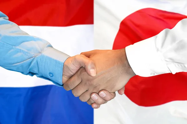 Jabat tangan di Jepang dan Belanda bendera latar belakang . — Stok Foto