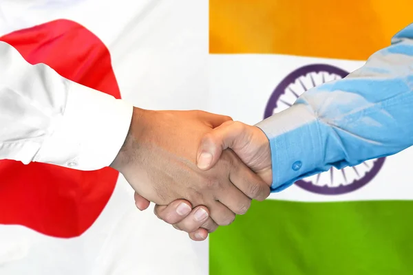 handshake on India and Japan flag background.