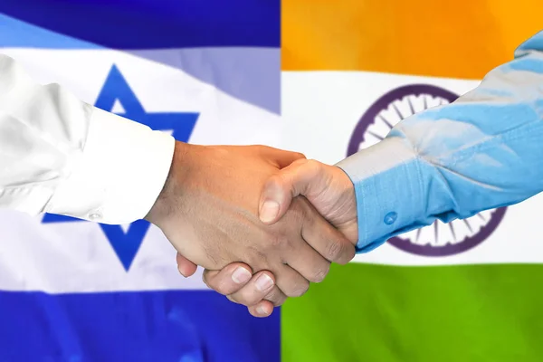 handshake on India and Israel flag background.