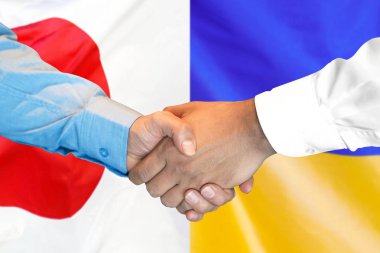 Japonya ve Ukrayna bayrağı arka plan üzerinde el sıkışma.