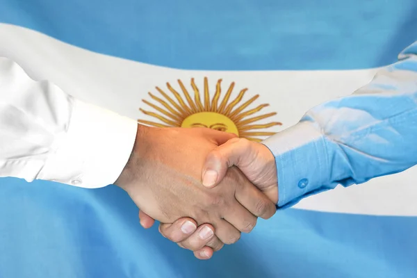 Handskakning på Argentina Flag bakgrund. — Stockfoto