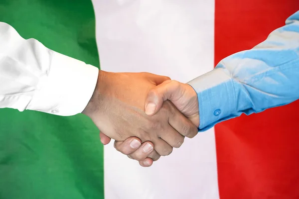 Handshake op Italië vlag achtergrond. — Stockfoto