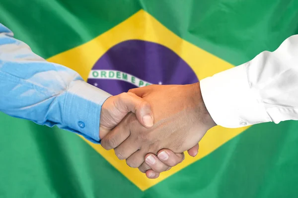 Handshake no fundo da bandeira do Brasil . — Fotografia de Stock