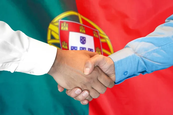 Handskakning på Portugal flagga bakgrund. — Stockfoto