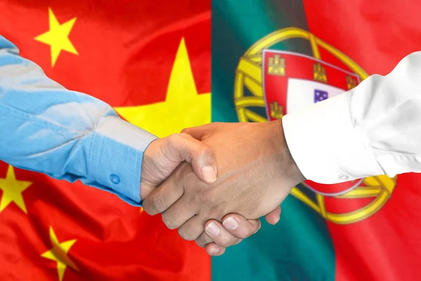 handshake on Portugal and China flag background.