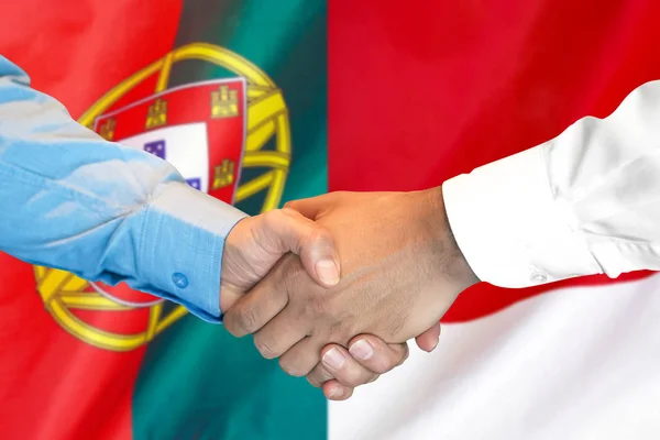 Handskakning om Portugal och Monaco flagga bakgrund. — Stockfoto