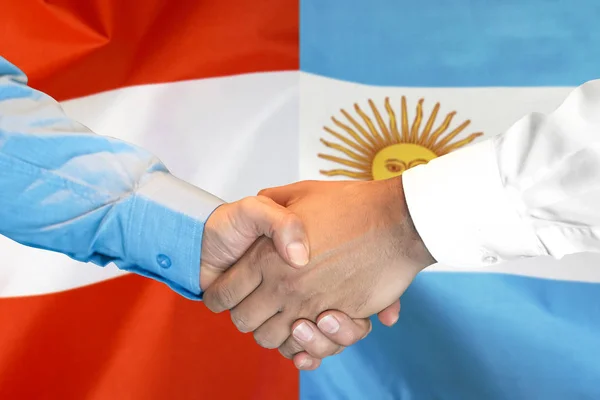 Handskakning om Argentina och Österrike flagga bakgrund. — Stockfoto