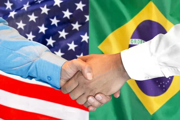 Aperto de mão no fundo da bandeira do Brasil e EUA . — Fotografia de Stock