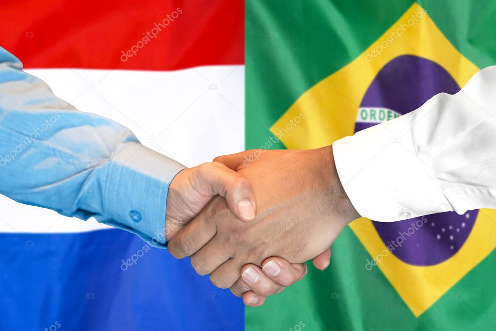 handshake on Brazil and Netherlands flag background.