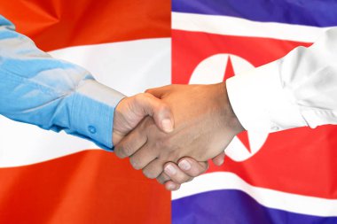 Avusturya ve Kuzey Kore bayrağı arka planda el sıkışması.