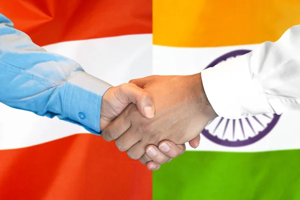 Hand skakning på Österrike och Indien flagga bakgrund. — Stockfoto