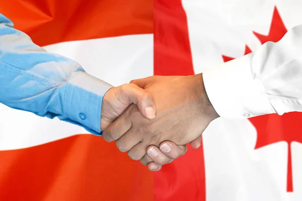 Apretón de manos sobre el fondo de la bandera de Austria y Canadá . — Foto de Stock