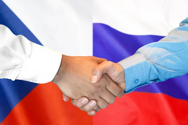 Рукопожатие на фоне флага Чехии и России . — стоковое фото