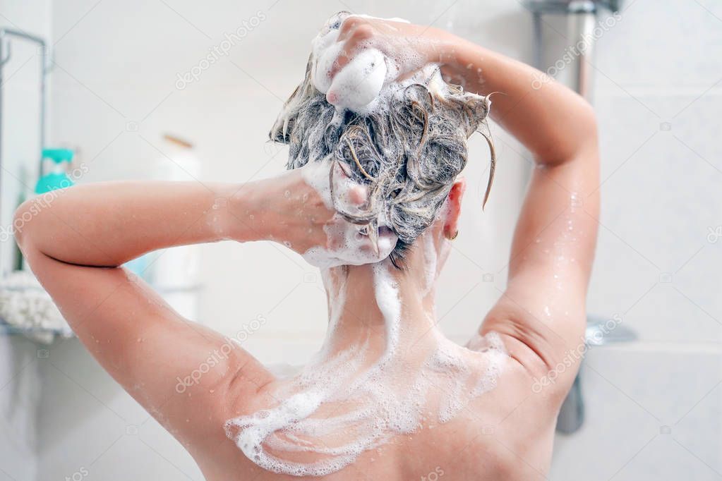 Back view of young woman washing her hair