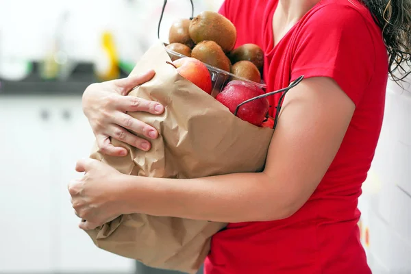 Main de fille avec des sacs de nourriture à la maison . — Photo