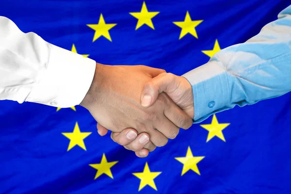 Рукопожатие на фоне флага Европейского Союза . — стоковое фото