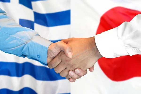 Handshake na Grecji i Japonii flaga tle. — Zdjęcie stockowe