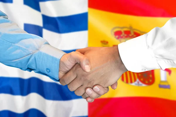 Aperto de mão no fundo da bandeira da Grécia e Espanha . — Fotografia de Stock
