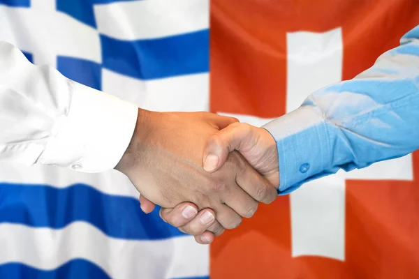 Handshake na Grecji i Szwajcarii flaga tle. — Zdjęcie stockowe