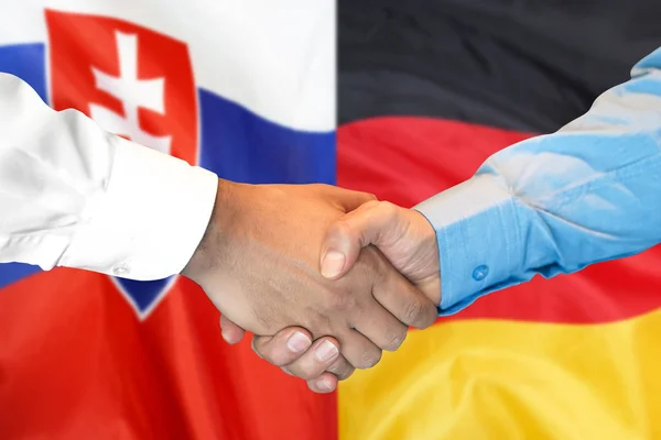 handshake on Slovakia and Germany flag background.
