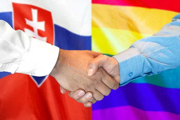 Рукопожатие на фоне гей-флага Словакии и ЛГБТ . — стоковое фото