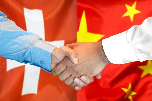 handshake on Switzerland and China flag background.