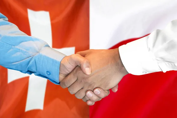 Apretón de manos sobre el fondo de la bandera de Suiza y Polonia . —  Fotos de Stock