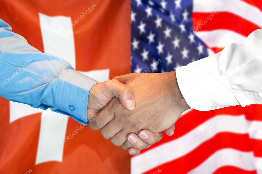 handshake on Switzerland and US flag background.