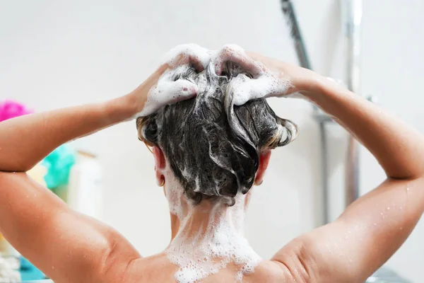 Visão traseira da jovem mulher lavando o cabelo — Fotografia de Stock