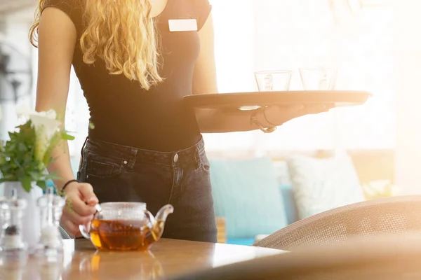 Mädchen, das als Kellnerin arbeitet und ein Tablett mit Tee hält — Stockfoto