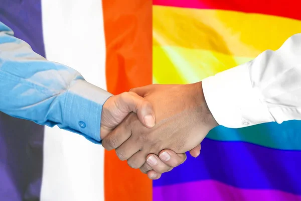 Stretta di mano su sfondo bandiera gay Francia e LGBT . — Foto Stock