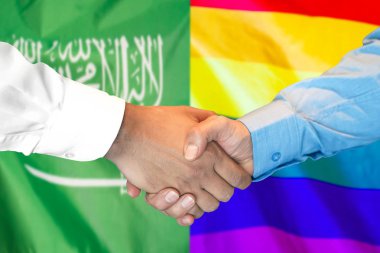 Suudi Arabistan ve Lgbt gay bayrağı arka plan üzerinde el sıkışma.