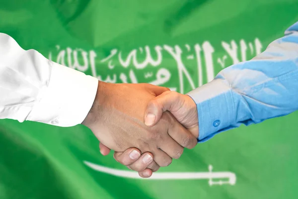 handshake on Saudi Arabia flag background.