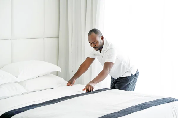 Elderly maid making Bed