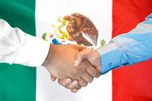 Рукопожатие на фоне флага Мексики . — стоковое фото