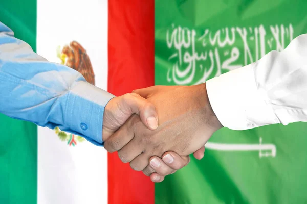 Рукопожатие на фоне флага Мексики и Саудовской Аравии . — стоковое фото