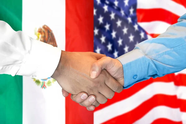 Podání ruky na pozadí vlajky Mexika a USA. — Stock fotografie