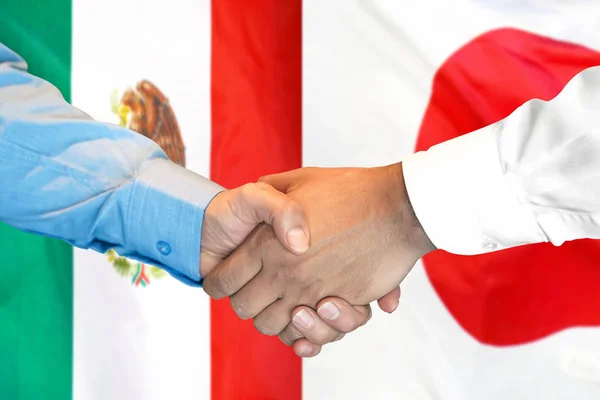 Apretón de manos en el fondo de la bandera de México y Japón . — Foto de Stock
