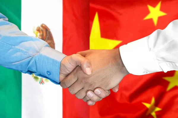 Apretón de manos en el fondo de la bandera de México y China . — Foto de Stock