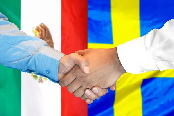 Apretón de manos sobre fondo de la bandera de México y Suecia . — Foto de Stock