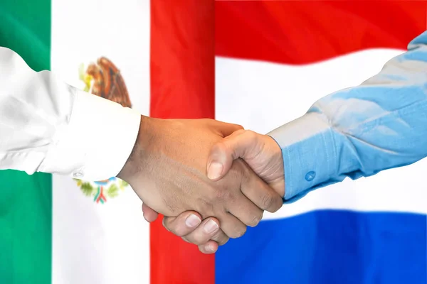 Kézfogás a mexikói és holland zászló háttér. — Stock Fotó