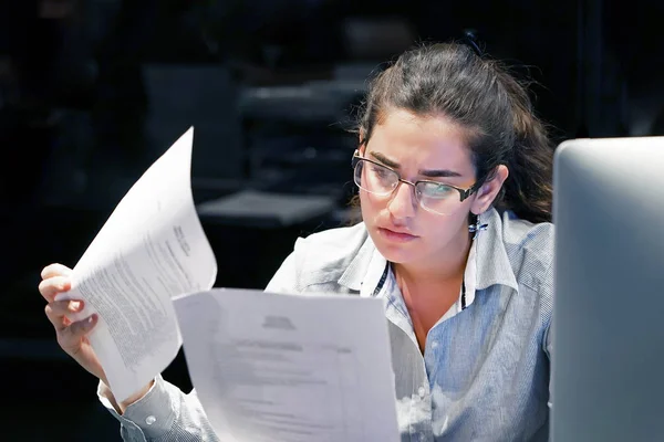 Mujer leyendo un documento en un espacio de trabajo de oficina —  Fotos de Stock