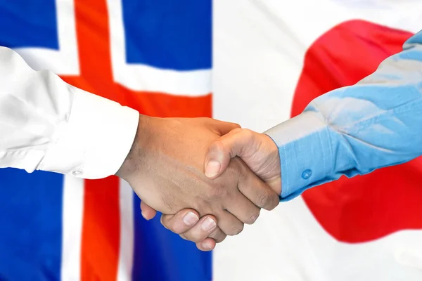 Kézfogás Izland és Japán zászlóval. — Stock Fotó